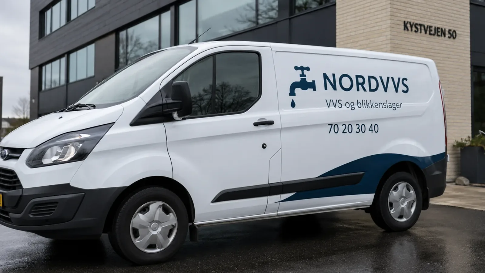 Hvid leaset varevogn med firmalogo i folie parkeret foran et kontorbyggeri